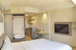 a bedroom with a bed and a desk in it at Lovina 1205 at Pollux Meisterstadt in Batam Center