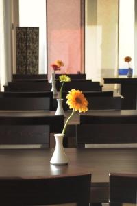 two vases with flowers in them on aasteryasteryasteryasteryasteryasteryastery at Hotel Atlas Halle in Halle an der Saale