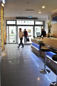 a group of people walking through a lobby at Hotel Atlas Halle in Halle an der Saale