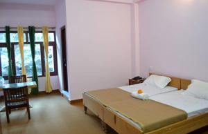 - une chambre avec un lit et une table avec une chaise dans l'établissement Vamoose Vijay Mount View, à Munsyari