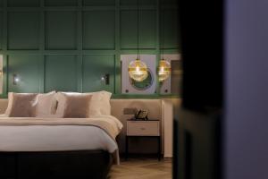 a bedroom with a bed and a green wall at The Embassy Valletta Hotel in Valletta