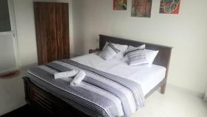 1 dormitorio con 1 cama con sábanas y almohadas blancas en Villa sierra sky, en Ambawela