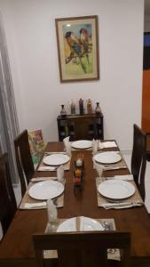 einem Holztisch mit Stühlen und Tellern darauf in der Unterkunft Villa sierra sky in Ambawela