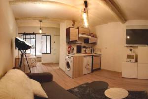 a living room with a couch and a kitchen at T2 à deux pas du Mucem au Panier / Vieux Port in Marseille