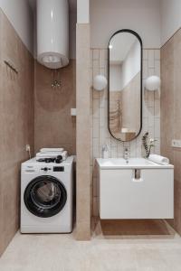 uma casa de banho com uma máquina de lavar roupa e um lavatório em NEW! Luxury apartment in the CENTER of ODESSA overlooking Deribasovskaya str. LOW PRICE! em Odessa