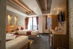 um quarto de hotel com duas camas e uma televisão em Hotel Mera Peak Private Limited em Pokhara