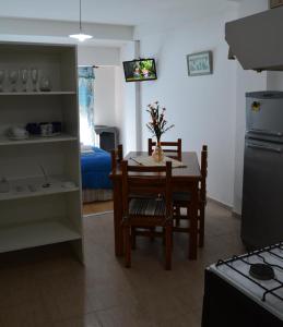 eine Küche mit einem Tisch und Stühlen sowie ein Zimmer mit einem Bett in der Unterkunft Excelente monoambiente in Neuquén