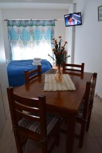 einen Esstisch mit einer Blumenvase darauf in der Unterkunft Excelente monoambiente in Neuquén