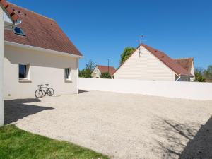 uma bicicleta estacionada ao lado de uma casa branca em Villa Tracy em Arromanches-les-Bains