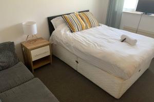 um quarto com uma cama com um candeeiro e uma cadeira em 'The Rockingham' 4 double beds, Netflix TVs, WIFI, parking em Corby