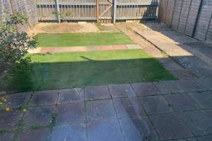 a yard with grass and a garden with a fence at 'The Rockingham' 4 double beds, Netflix TVs, WIFI, parking in Corby