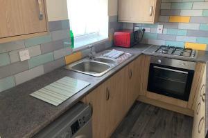 a kitchen with a sink and a stove at 'The Rockingham' 4 double beds, Netflix TVs, WIFI, parking in Corby