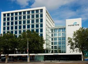 a large building with a clock on the front of it at Motel One Amsterdam in Amsterdam
