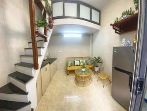 a room with a staircase and a table and a refrigerator at HnH homestay in Hanoi