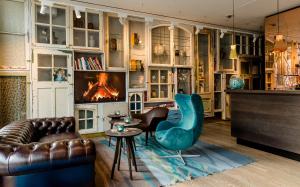 - un salon avec un canapé et une cheminée dans l'établissement Motel One Amsterdam-Waterlooplein, à Amsterdam