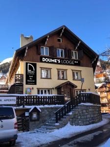 a building with a car parked in front of it at Doume's Lodge in Les Deux Alpes