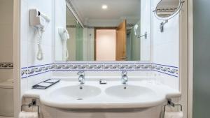 a bathroom with a white sink and a mirror at Be Live Family Palmeiras Village All-Inclusive 24H in Armação de Pêra