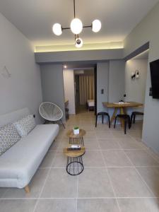 a living room with a couch and tables at Stefani apartments in Methana