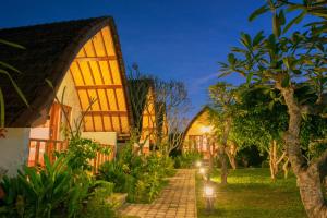 a pathway in front of a house at night at kaje cottage & restaurant in Nusa Penida