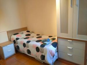 ein kleines Schlafzimmer mit einem Bett mit einer kugelgemusterten Decke in der Unterkunft Acogedor duplex a 15min de Marbella in Monda