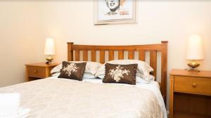 a bedroom with a bed with two night stands and two lamps at Ruthmor Villas in Toowoomba +34 photos