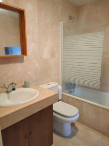 een badkamer met een toilet, een wastafel en een bad bij Acogedor duplex a 15min de Marbella in Monda