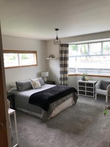 a bedroom with a large bed and a window at Fitzroy Gem in New Plymouth