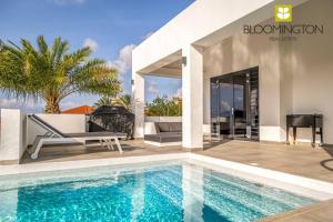 a villa with a swimming pool and a house at Villa Blue Bay Curacao in Dorp Sint Michiel