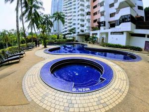 a large blue pool in a courtyard in a building at Airbnb at Sri Sayang Batu Ferringhi Beach in Batu Ferringhi
