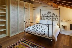 una camera con letto e testiera in ferro battuto di Casa Gugù a Ravenna