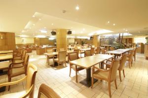 a restaurant with wooden tables and chairs in it at Hotel Avenue in Hsinchu City