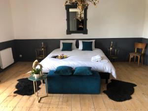 um quarto com uma cama grande e um sofá azul em La Belle Epoque - Chambres d'hôtes & SPA em Damvix