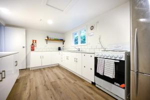 a kitchen with white cabinets and a stainless steel refrigerator at U Boutique on Haven in Nelson