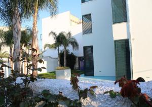 ein weißes Gebäude mit Palmen davor in der Unterkunft appartamento petraroli by salentolimit in Porto Cesareo