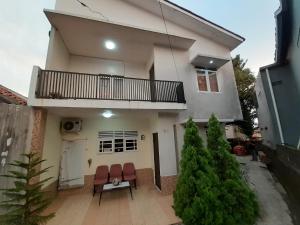 a house with two chairs and a balcony at Kost Carmelia Syariah Baranangsiang Bogor in Bogor