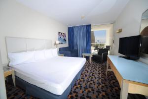 een hotelkamer met een groot bed en een televisie bij Sport Club by Isrotel Collection in Eilat