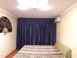 a bedroom with a bed and a blue curtain at пр. Александра Поля 100, центральная часть города in Dnipro