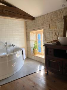 a bathroom with a tub and a sink and a window at La Belle Epoque - Chambres d'hôtes & SPA in Damvix