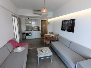 ALOS SUITES ex-Possirama Bay aparts في كارباثوس: غرفة معيشة مع أريكة وطاولة