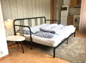 a bed in a small room with a table and a kitchen at Villa Holmen 2 - Ground floor apartment in Balestrand