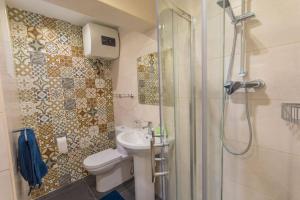 a bathroom with a shower and a toilet and a sink at Central Valletta house in Il-Furjana