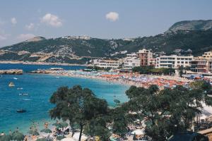 a beach with a lot of people in the water at Villa Alba Apartments in Dobra Voda