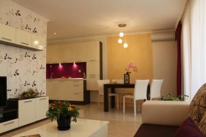 Vello Apartments في بايالا: مطبخ وغرفة معيشة مع طاولة وكراسي