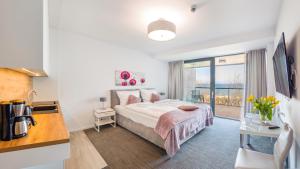 sypialnia z łóżkiem i dużym oknem w obiekcie Apartamenty Sun & Snow Seaside Kołobrzeg w Kołobrzegu