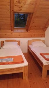 two beds in a room with wooden ceilings at Turizem Pavlin Apartments in Šenturska Gora
