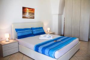 a bedroom with a bed with blue and white sheets at Complesso Centopietre by TerraSalento in Castrignano del Capo