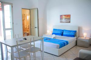 a bedroom with a bed and a table and chairs at Complesso Centopietre by TerraSalento in Castrignano del Capo