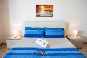 sypialnia z łóżkiem z niebieską pościelą i 2 lampami w obiekcie Complesso Centopietre by TerraSalento w mieście Castrignano del Capo