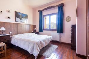 a bedroom with a large bed and a window at Apartamentos Tanau in Baqueira-Beret