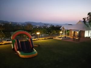 a playground with a slide in the grass at Villa Paradiso in Hartbeespoort